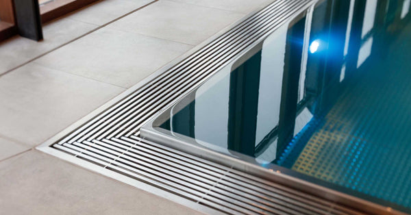 Goulotte et caillebotis en inox d'un bassin à débordement, à coordonner avec l'intégration d'un volet de sécurité