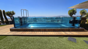 Piscine transparente en inox et verre sur la terrasse de la résidence Le Diana à Cannes, paroi vitrée vue depuis la plage