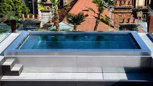 Piscine rooftop en inox sur une toiture-terrasse à Reims, au milieu des toits de la ville