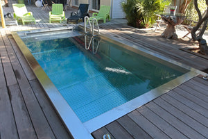 Piscine en inox 316L sur mesure encastrée dans une terrasse en bois, cuve soudée et finition brossée