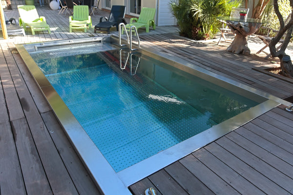 Piscine en inox 316L sur mesure encastrée dans une terrasse en bois, cuve soudée et finition brossée