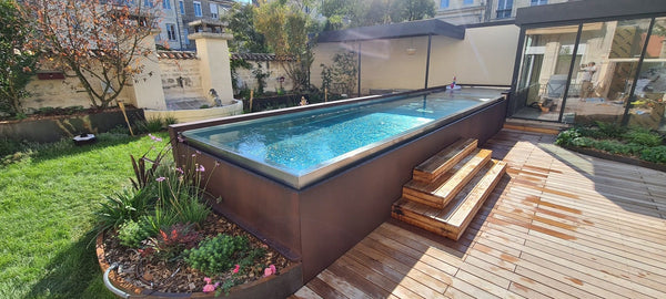 Piscine inox sur le toit-terrasse jardiné d’un hôtel particulier à Bordeaux, deck et marches en bois