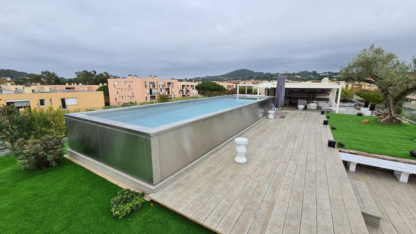 Piscine inox hors sol sur un toit-terrasse à Saint-Tropez, terrasse en bois et gazon