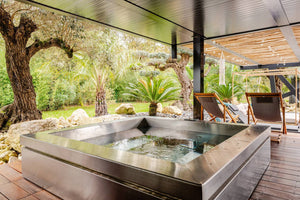 Spa en inox STEEL AND STYLE Spakub 4 places avec jets et sièges confortables, visible avec ses éléments en acier brillant.